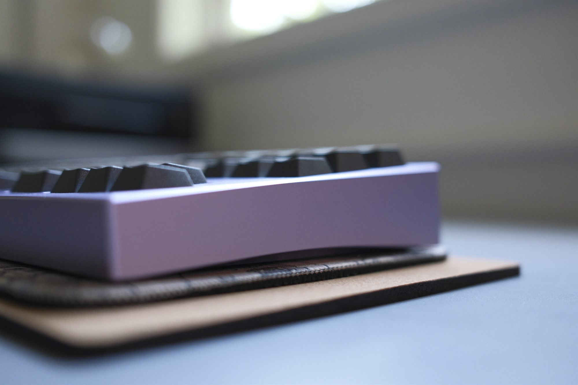 Cruel World CW87, three-quarter side profile — purple anodized case with grey and cream GMK NTD keycaps
