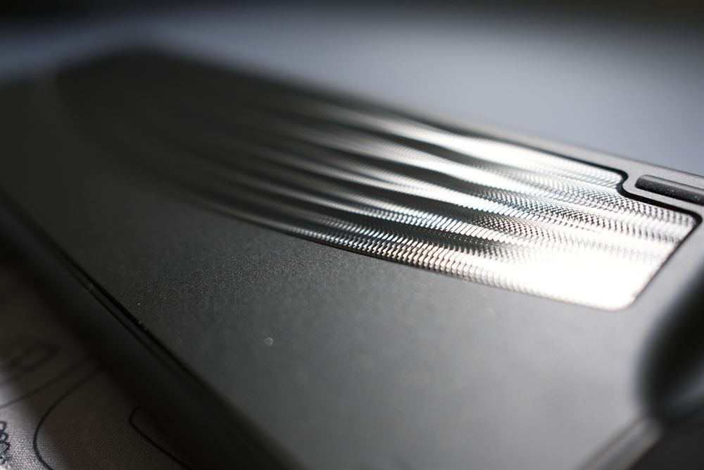 Macro of the silver machined guilloché wave pattern catching light